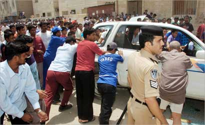 بنغلاديشيون غاضبون يقلبون سيارة في الحساوي على مرأى من رجل الأمن (تصوير مرهف حورية)