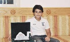 اصغر ابنائه ممسكاً بدرع «شكر وعرفان» من لجنة مزاين الابل