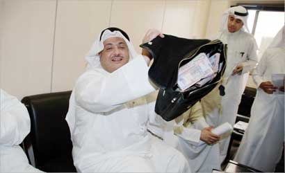 محمد الجويهل في إدارة شؤون الانتخابات امس يعرض الأموال التي سيقدمها للمرشحين الجدد في الدائرة الثالثة (تصوير احمد عماد)