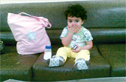 الطفلة ورضاعتها وكيس ملابسها وحفاضاتها