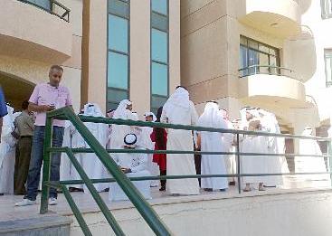 مواطنون ينتظرون دورهم خارج المبنى