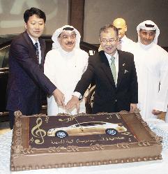 أحمد المطوع والسفير الياباني يقطعان قالب حلوى عليه صورة السيارة  (تصوير طارق عز الدين)