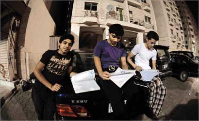 طلاب يذاكرون للامتحانات في ضوء فوانيس السيارات بعد انقطاع الكهرباء في حولي 	 (تصوير موسى عياش)