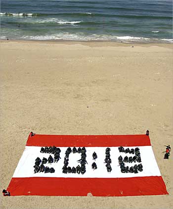 شباب لبنانيون يرسمون بأجسادهم الرقم 12: 20 على علم وطني رمزي عملاق على أحد شواطئ بيروت أمس خلال تظاهرة احتجاجية بيئية ارادوا من خلالها ان يحضوا الحكومات العربية على أن تعمل على تقليص انبعاثات غاز ثاني اكسيد الكربون بنسبة 20 في المئة قبل حلول العام 2012 في اطار الاستجابة للجهود العالمية الرامية لمكافحة ظاهرة الاحتباس الحراري (ا ف ب) 