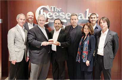 الشايع وأوفرتون يحملان «تشيز كيك» بين عدد من مسؤولي الشركة الاميركية