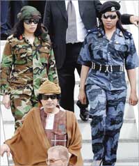 القذافي متبوعا باثنتين من حارساته الجميلات