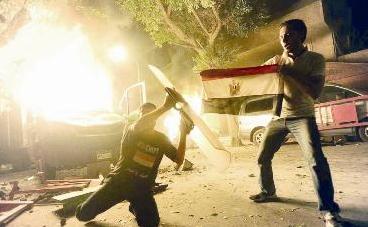 ... وآخر يرفع علم مصر قرب سيارة مشتعلة امام السفارة ليل اول من أمس 	(خاص - «الراي»)