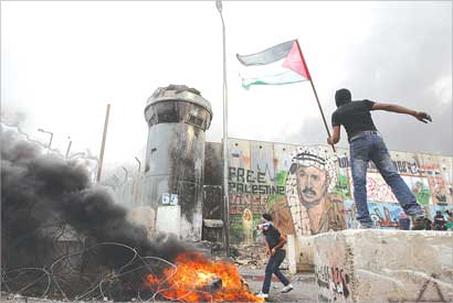 u0645u062au0638u0627u0647u0631 u064au0636u0639 u0639u0644u0645u0627 u0641u0644u0633u0637u064au0646u064au0627 u0639u0644u0649 u0627u0644u062cu062fu0627u0631 u0627u0644u0641u0627u0635u0644 u0639u0646u062f u062du0627u062cu0632 u0642u0644u0646u062fu064au0627 u0641u064a u0627u0644u0636u0641u0629 u0623u0645u0633 (u0631u0648u064au062au0631u0632) 