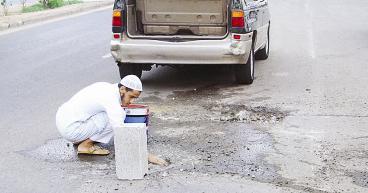 شاب يتطوع لردم حفرة في الطريق لتجنيب الناس أذاها