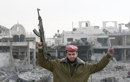 شرطي من «حماس» يحتفل بعد عودته إلى مبنى «السرايا» الرئيسي المدمر في غزة أمس 	(أ ف ب)