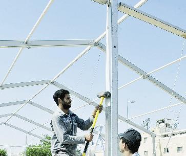 نصب الأخشاب تمهيداً لوضع الخيمة	(تصوير موسى عياش)