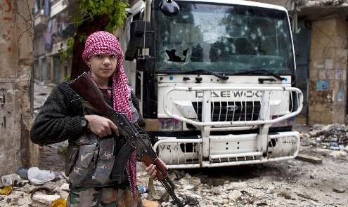 عبدالقادر زيدان (15 عاماً) يقف مسلحاً في حي صلاح الدين في حلب 	(ا ف ب)