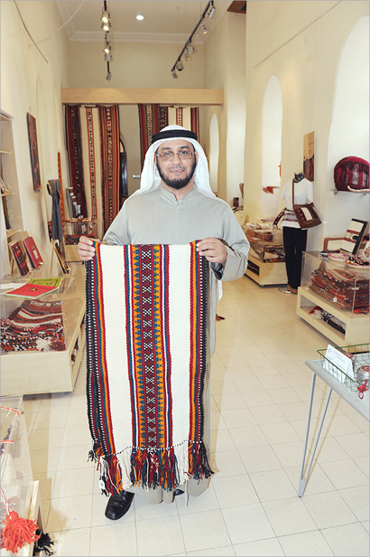 الزميل سعود الديحاني ممسكاً بقطعة من منتجات السدو