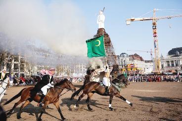 الفرسان بالشماغ والعقال والبشت فوق خيولهم حول رجل الثلج في ميدان سيكسيلوتن