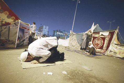 مؤيد لحازم ابو اسماعيل يصلي في ميدان التحرير مساء اول من امس 	(اب)