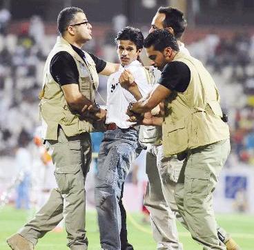 قوات الأمن تحكم قبضتها على أحد الأشخاص حاول النزول إلى أرض الملعب	(تصوير جلال معوض)