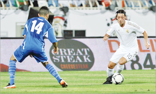 مسعود اوزيل نجم اللقاء يتقدم بالكرة ويحاول تخطي طلال العامر (الأزرق دوت كوم) 