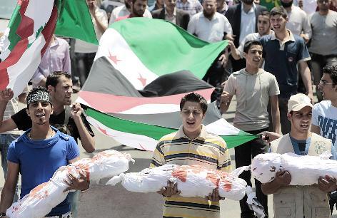 متظاهرون لبنانيون يحملون مجسمات لجثث اطفال خلال تظاهرة مناهضة للنظام السوري في صيدا امس  		(ا ب)