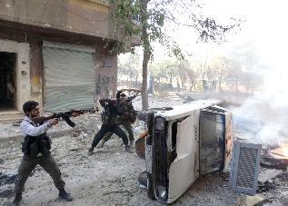 مسلحون يحتمون خلف سيارة ويطلقون الرصاص خلال اشتباكات في منطقة صلاح الدين في حلب	(أ ف ب)