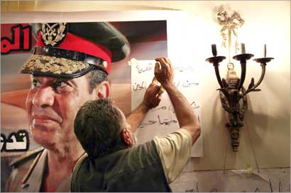 مصري يعلّق صورة كبيرة للسيسي في فندق «بيرا ميزا» في القاهرة (ا ب)