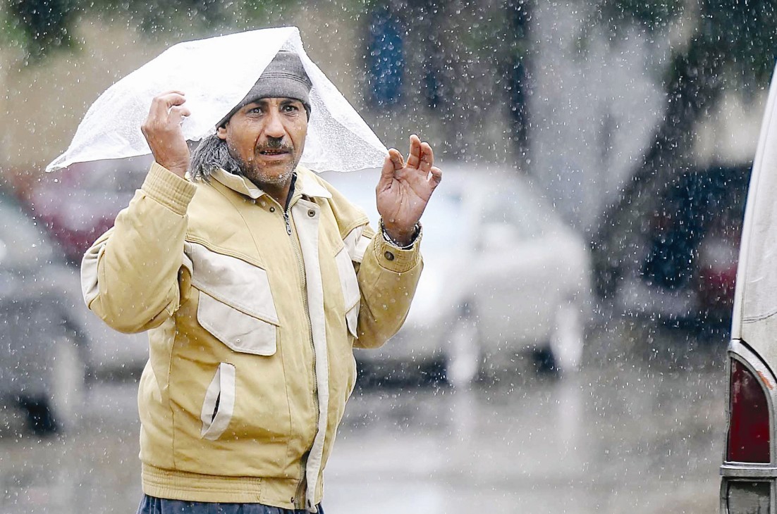 مصري يحتمي بكيس نايلون من تساقط الثلج