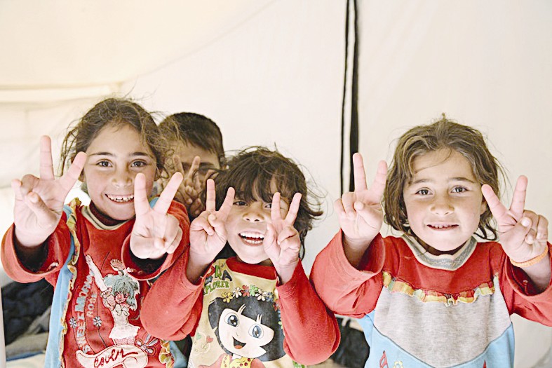 أطفال سوريون يشيرون بعلامة النصر