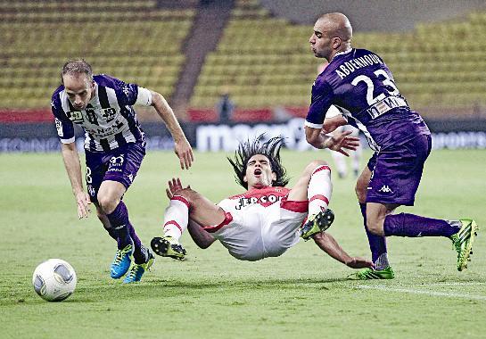 لاعب موناكو فالكاو يتوسط لاعبي تولوز دي دوت وايمن عبدالنور			 (ا ب)