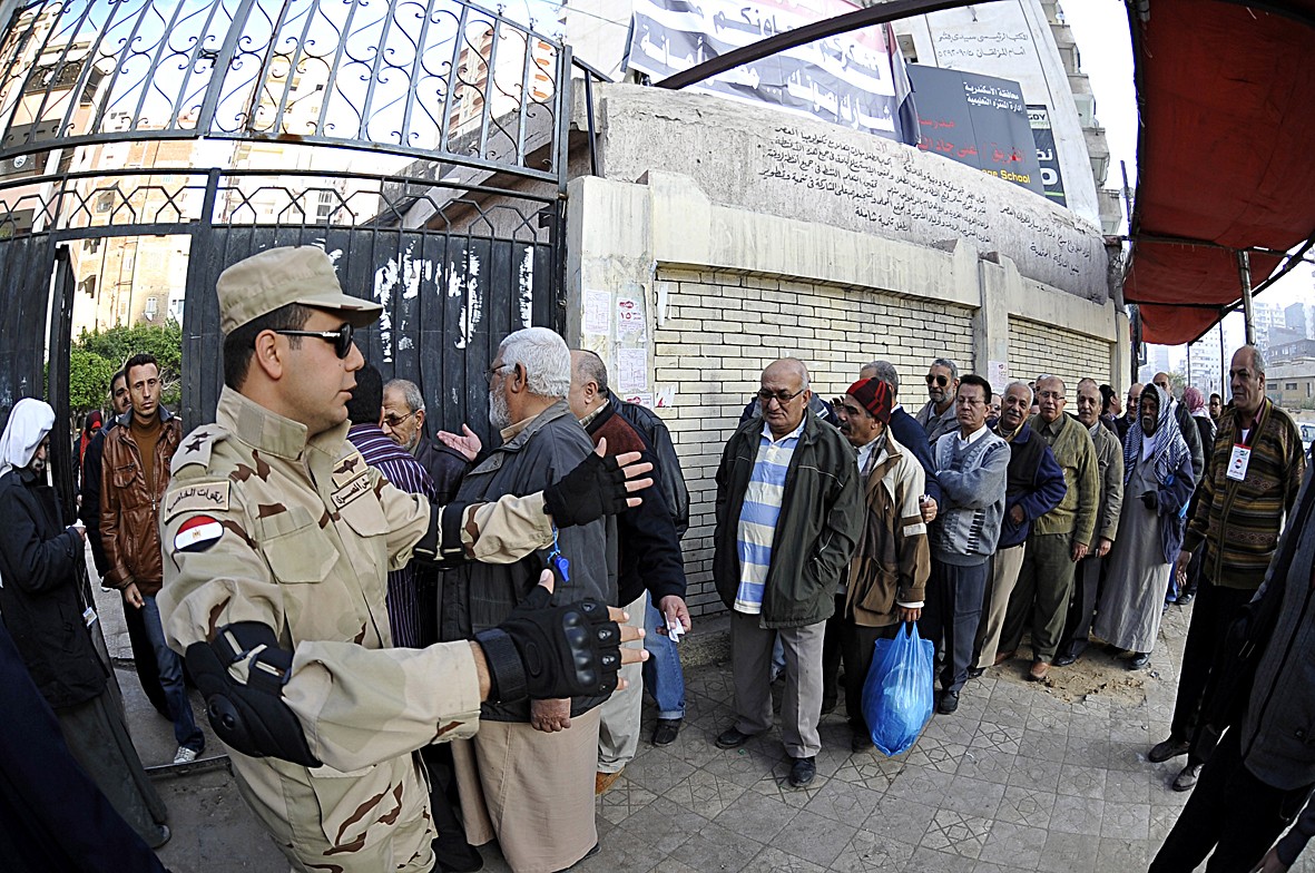 ضابط في الجيش ينظم دخول المقترعين إلى أحد مقار الاستفتاء في الإسكندرية أمس (اف ب)