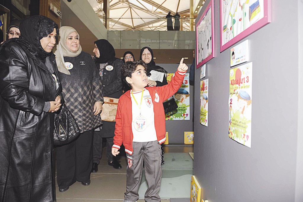 احد الأطفال يشرح الرسوم للضيوف (تصوير جلال معوض)
