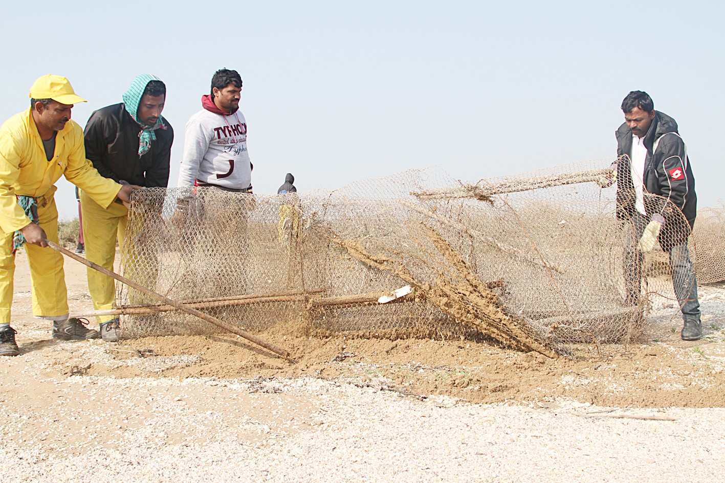 .... وعمال يرفعون اسلاك الحظرات والقراقير القديمة