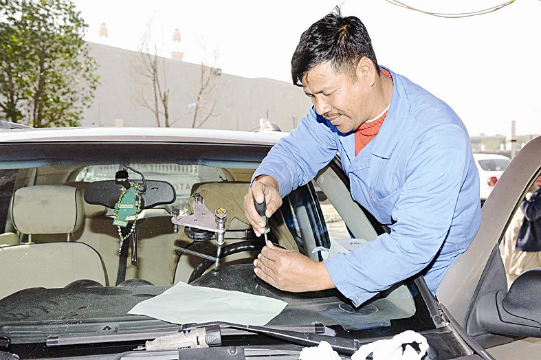 فني يصلح زجاج سيارة