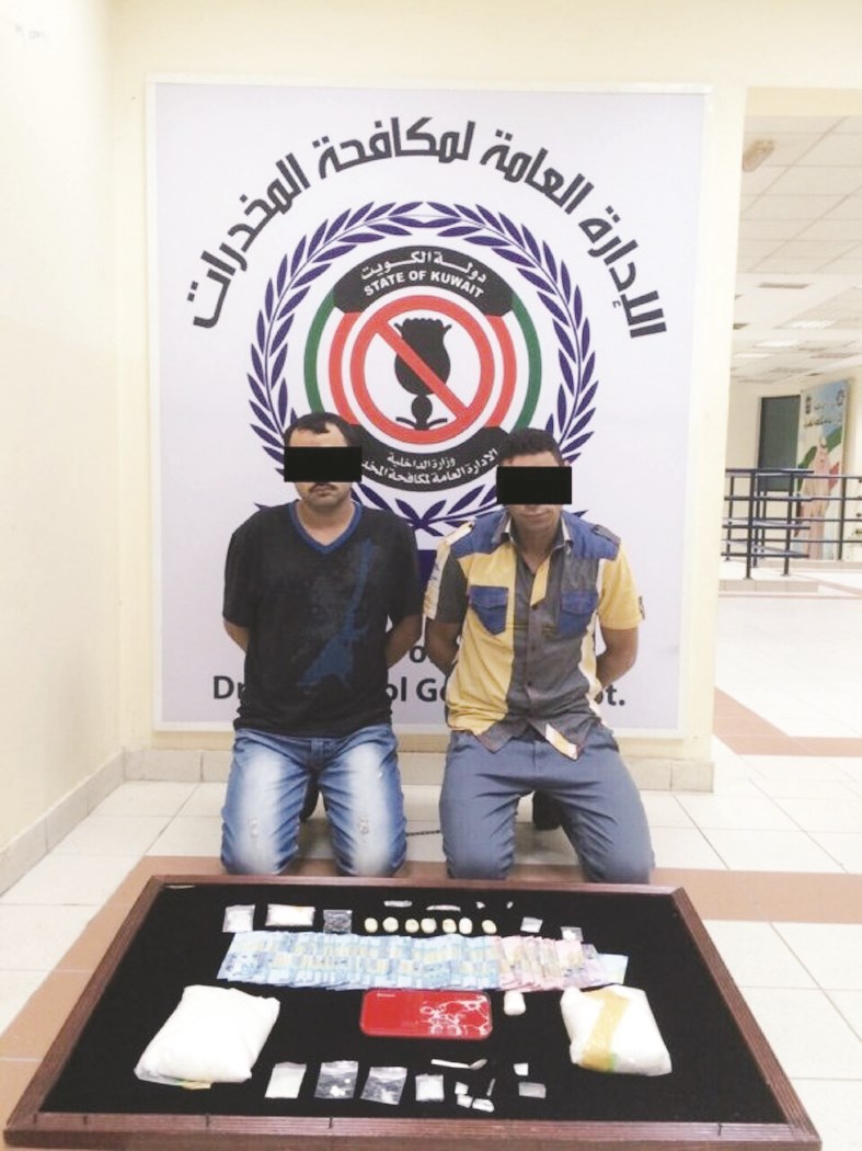 المتهمان وأمامهما المضبوطات