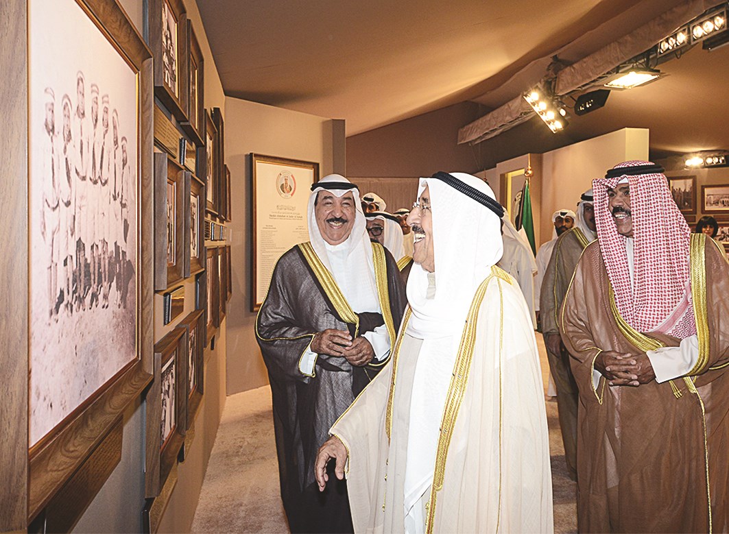 ابتسامة مشتركة للأمير وولي العهد وجابر العبدالله لدى الاطلاع على صور المعرض المرافق