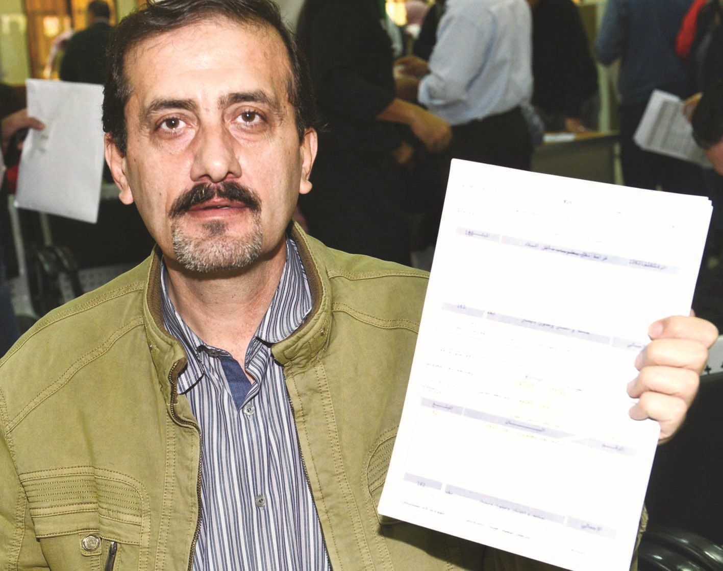 وافد يمسك باستمارة تجديد جواز السفر