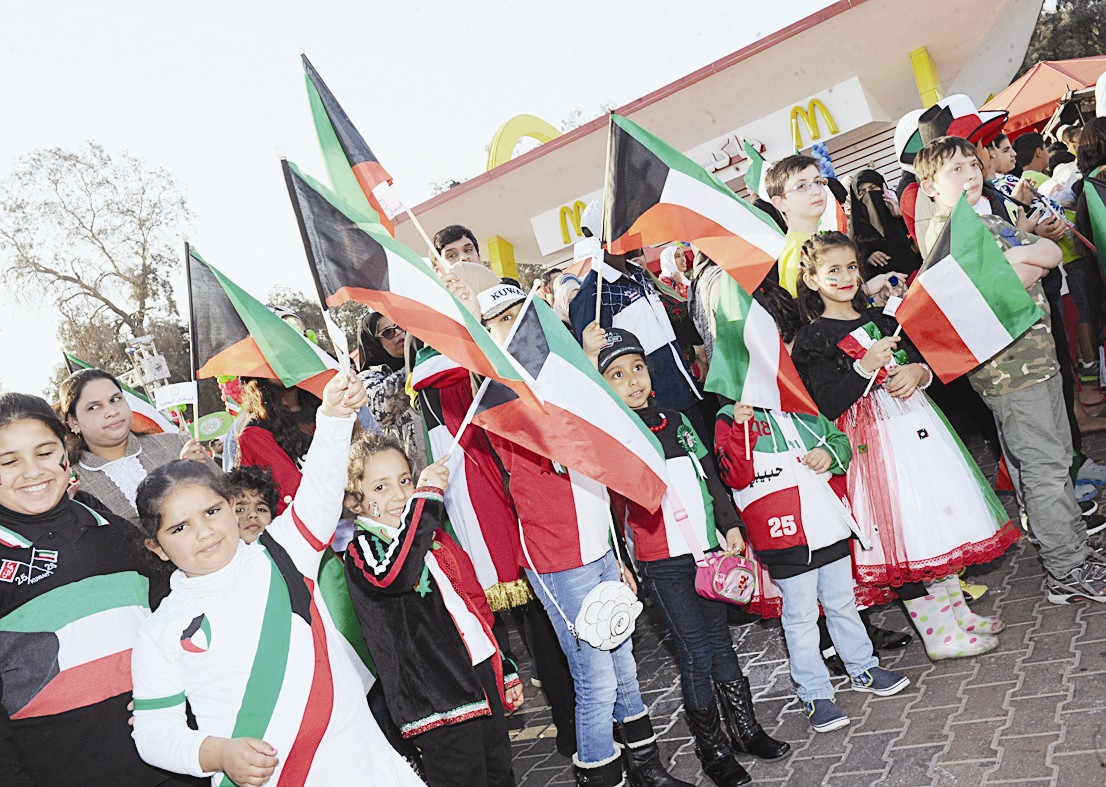 أطفال يلوحون بعلم الكويت