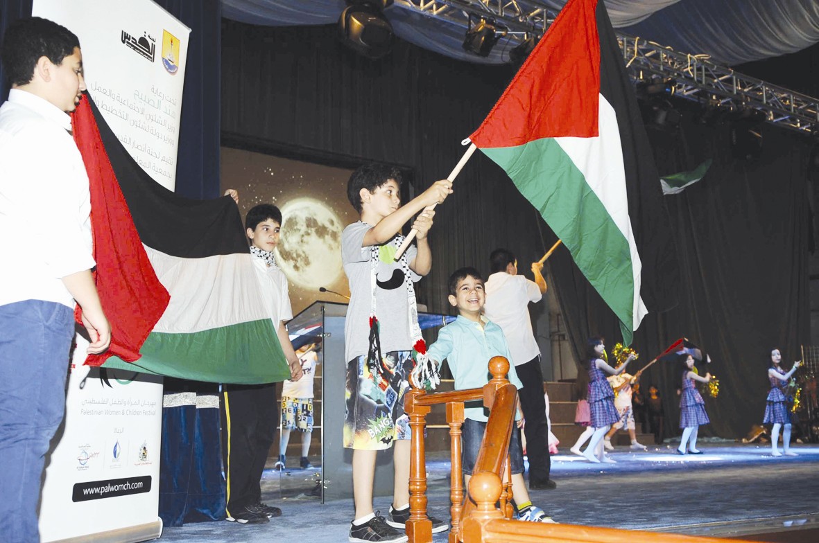 أطفال في الحفل يرفعون الأعلام