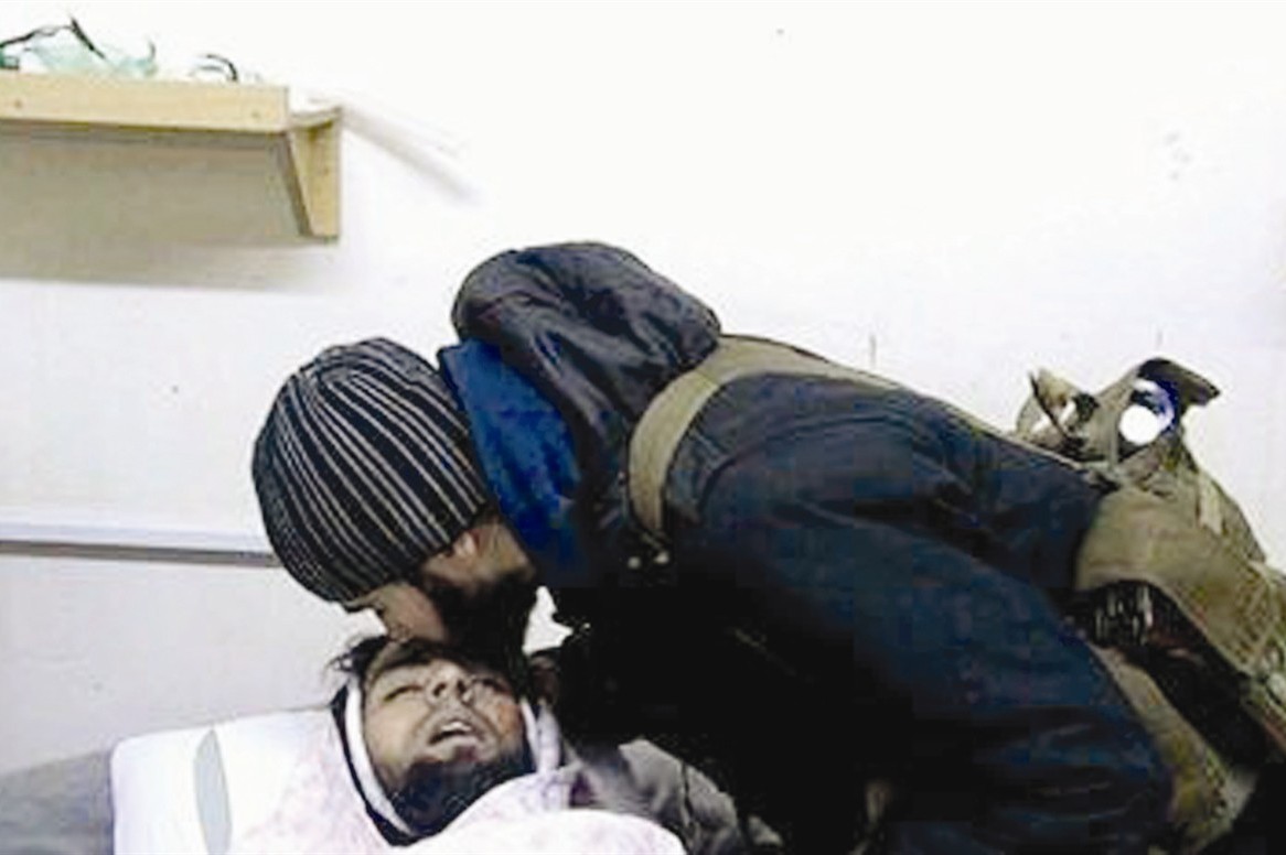 قبلة على جبينه بعد استشهاده من هادي العبدالله الناطق باسم الثورة في الداخل