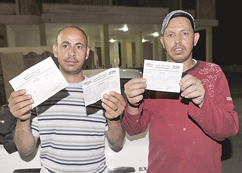 وافدان يعرضان إيصالات تؤكد على تسديدهما الإيجارات
