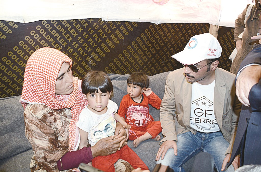 الغانم يجلس الى جوار عائلة نازحة مواسيا