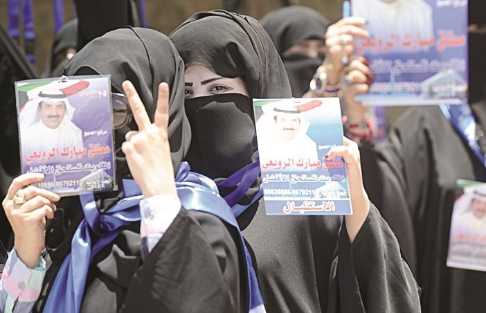 ناخبة ترفع صورة مرشحها وعلامة النصر