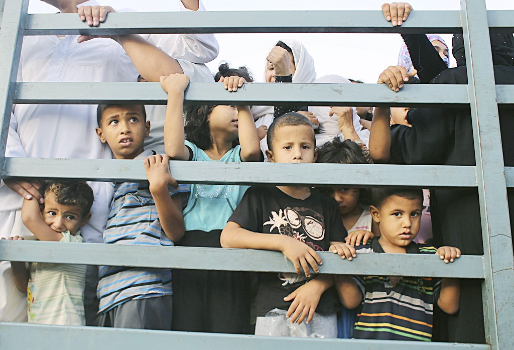 أطفال فلسطينيون في شاحنة مكدسة بالنازحين أثناء فرارهم من خان يونس  (رويترز)