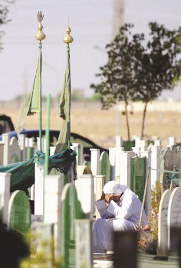 رجل يجهش بالبكاء أمام المقبرة