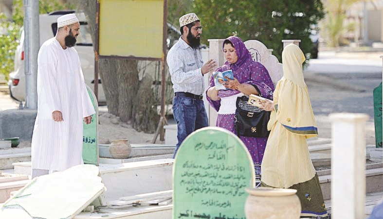 سيدة تتلو القرآن بجوار مجموعة من الوافدين الآسيويين