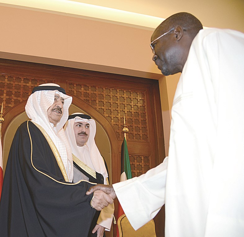 خليفة بن سلمان مصافحاً أحد السفراء