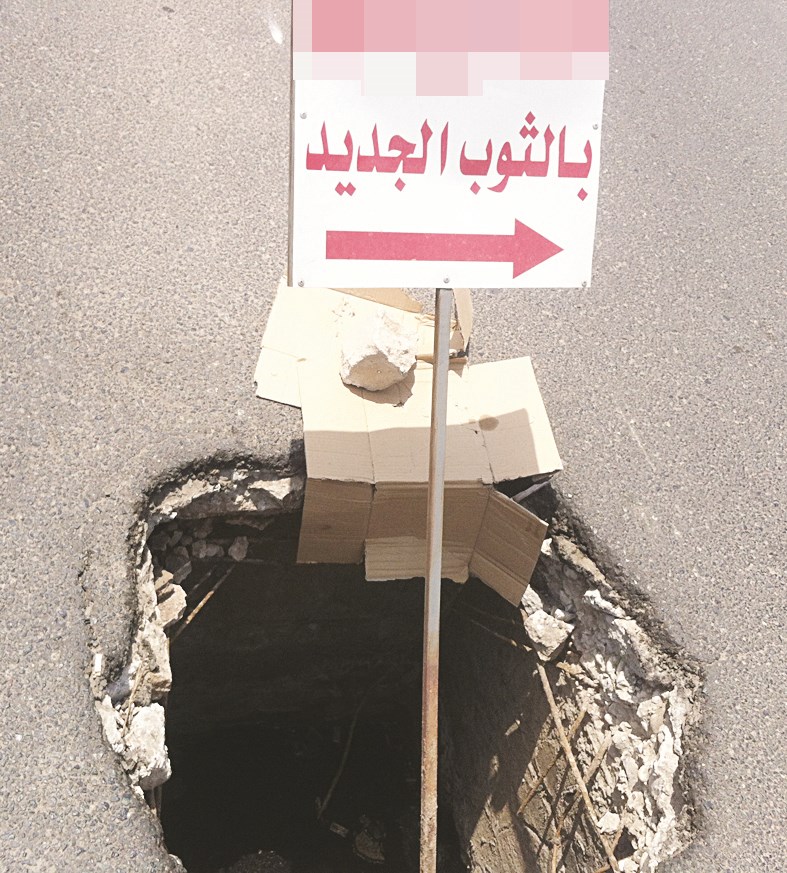 صاحب مقهى وضع اعلاناً لمقهاه في لوحة تحذيرية ضمن حفرة وسط الطريق