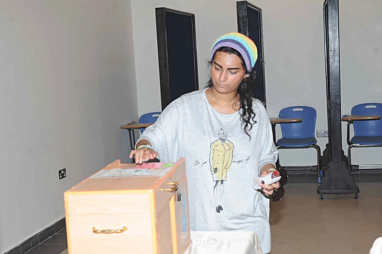 طالبة تضع ورقة الاقتراع في الصندوق