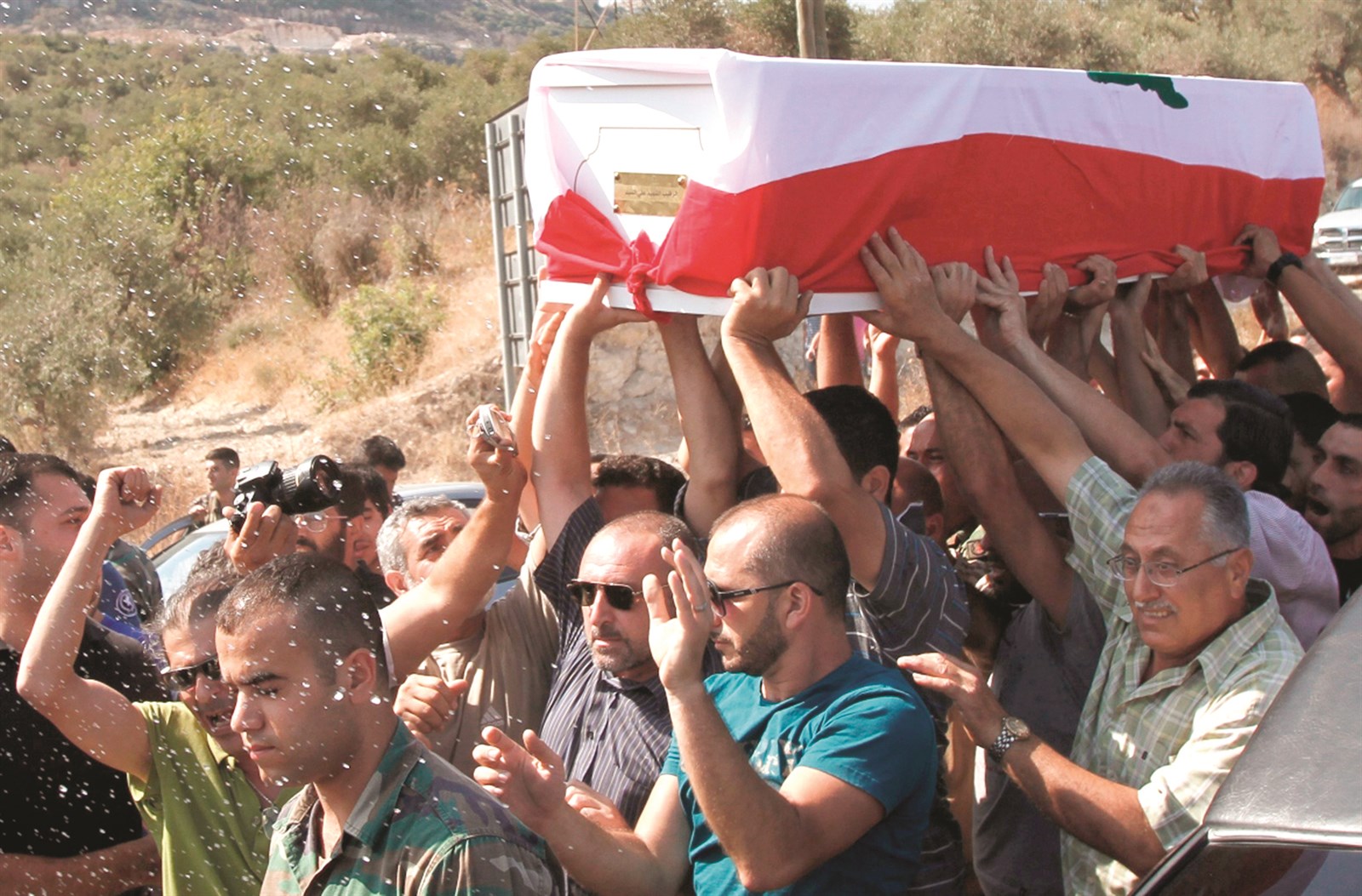 u0645u0634u064au0639u0648u0646 u064au062du0645u0644u0648u0646 u0646u0639u0634 u0627u0644u062cu0646u062fu064a u0627u0644u0644u0628u0646u0627u0646u064a u0639u0644u064a u0627u0644u0633u064au062f u0627u0644u0630u064a u0642u0637u0639 u0645u0633u0644u062du0648u0646 u0645u0646 u00abu062fu0627u0639u0634u00bb u0631u0623u0633u0647 u0623u062eu064au0631u0627u064b u0641u064a u0628u0644u062fu0629 u0639u0631u0633u0627u0644 (u0631u0648u064au062au0631u0632)