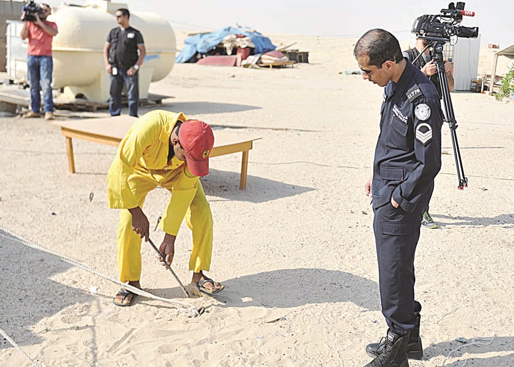 عامل يزيل بقايا جاخور وشرطي مرافق يتابع