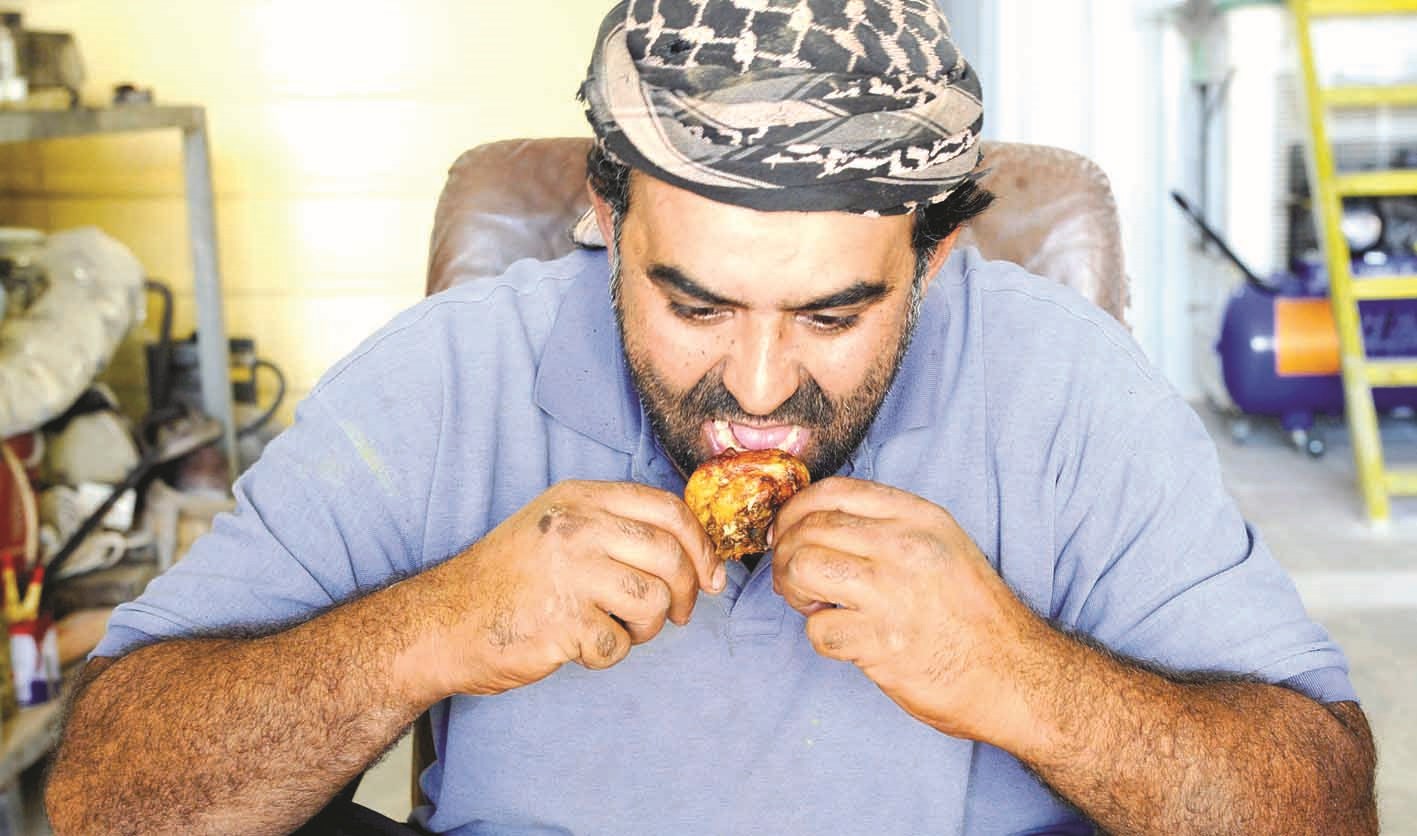 عامل يلتهم وجبته ذات الدنانير الثلاثة  (تصوير نايف العقلة)