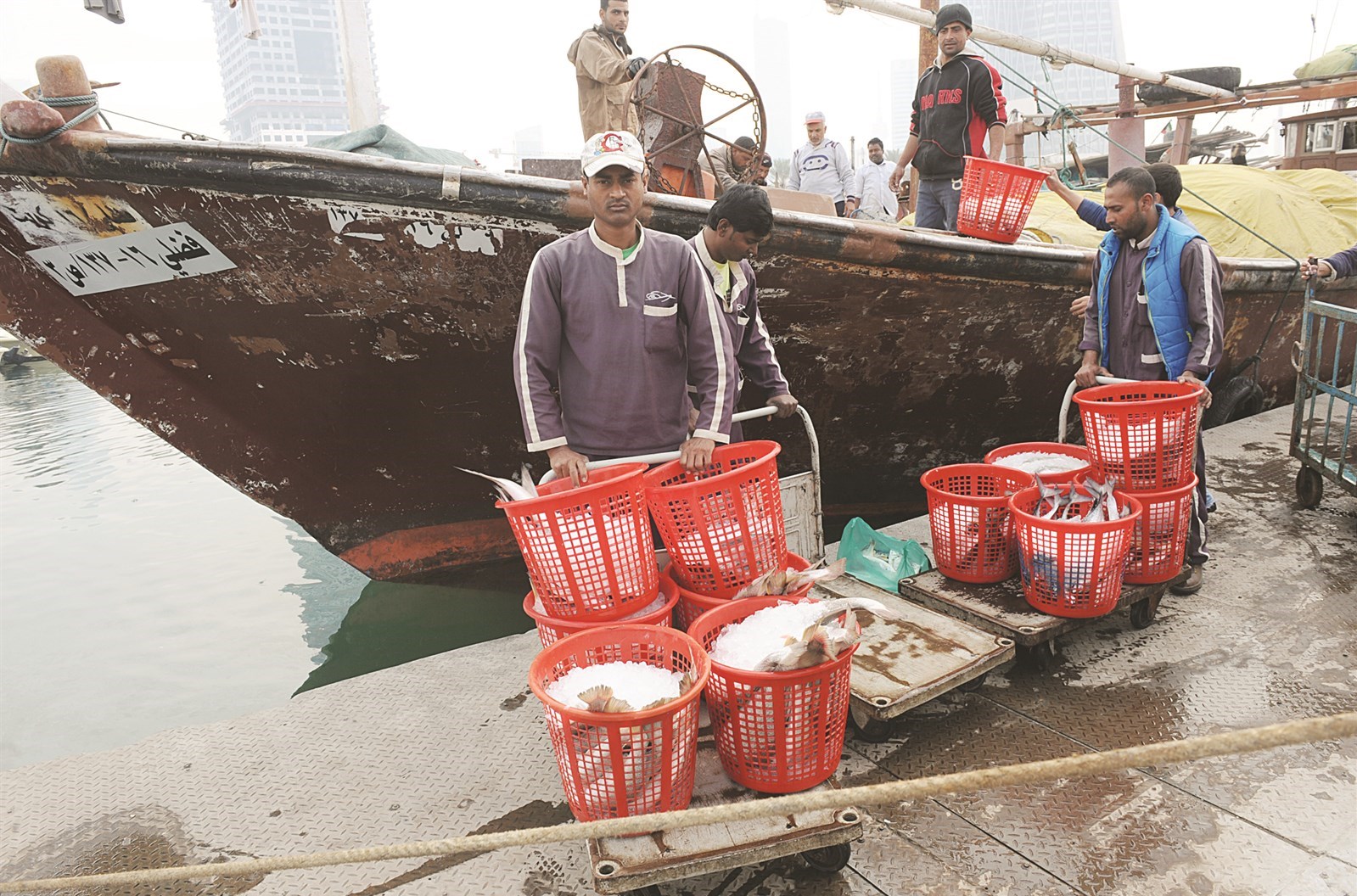 صيادون يفرغون حصيلة صيدهم من المياه الكويتية